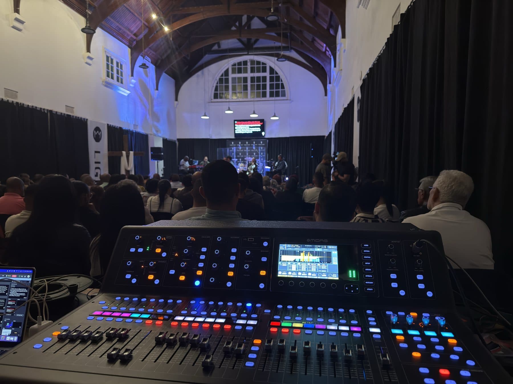 Front-of-house mixing console during a live service in a historic hall